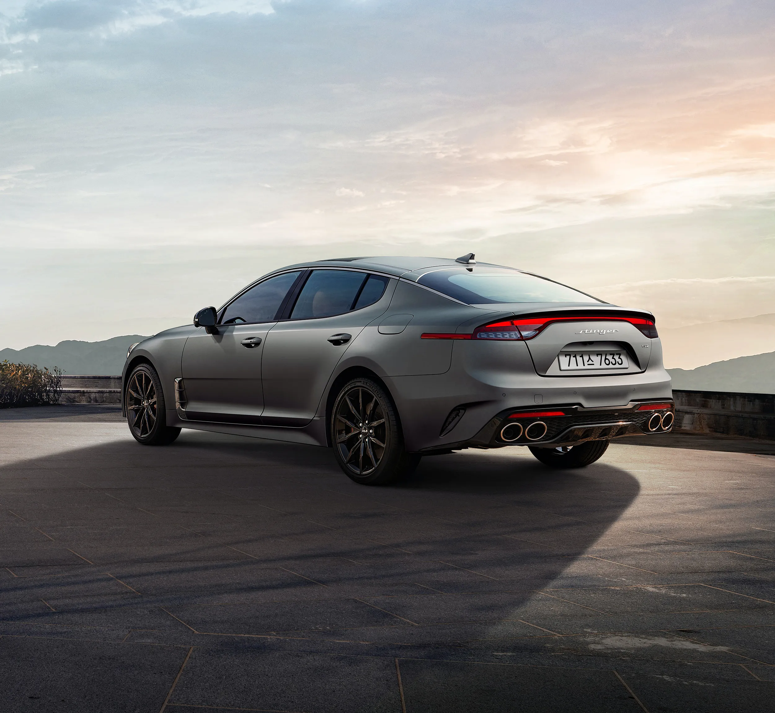 Rear view of a gray sports sedan at an overlook