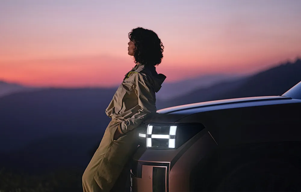 Customer leaning on a truck hood at sunset