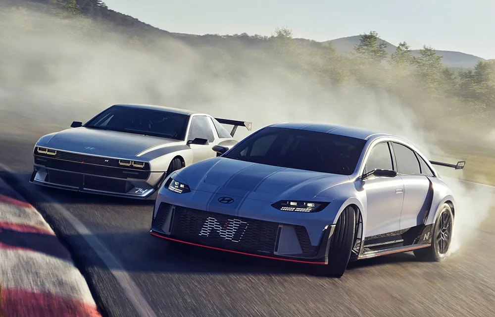 Two performance cars driving in morning fog